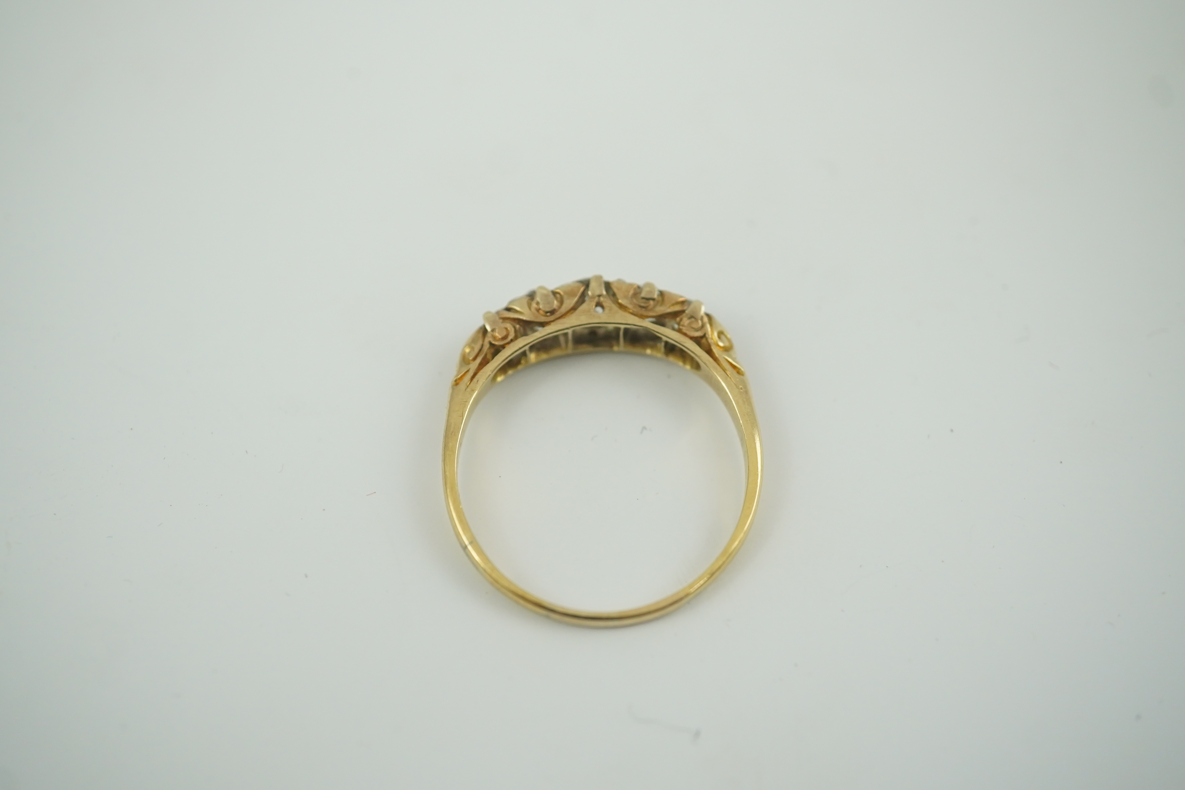 An early 20th century gold and graduated five stone old cut diamond set half hoop ring